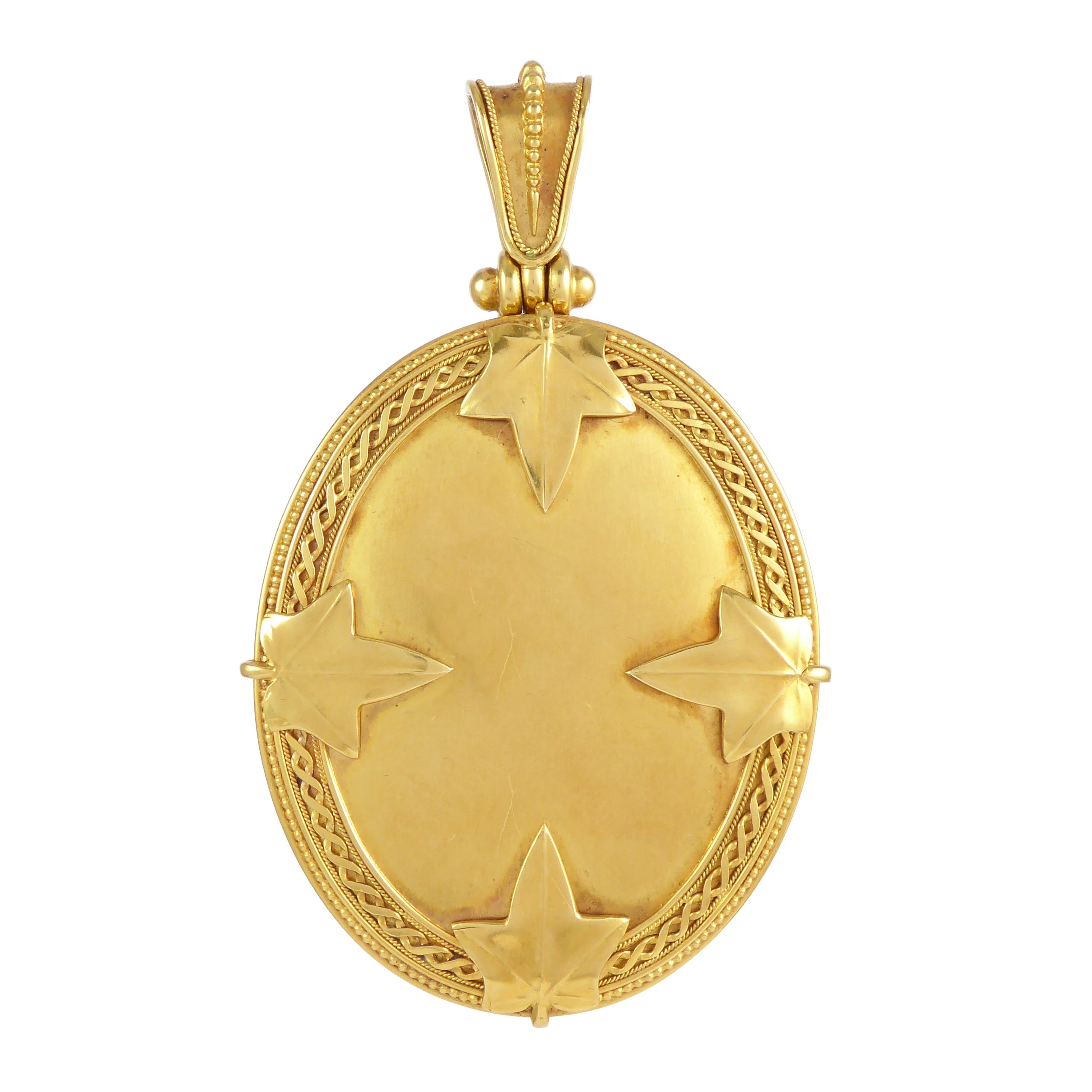 19th century gold oval locket pendant by Carlo Giuliano, London c.1870, applied to front with four ivy leaves,